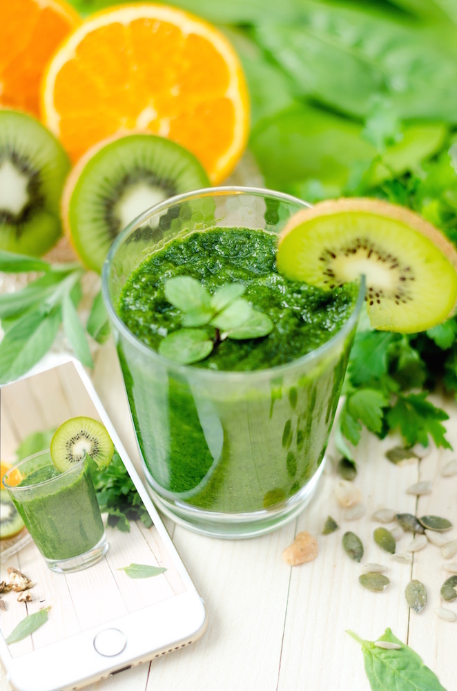 un jus vert et des tranches d'agrumes et de kiwi symboles de vitalité